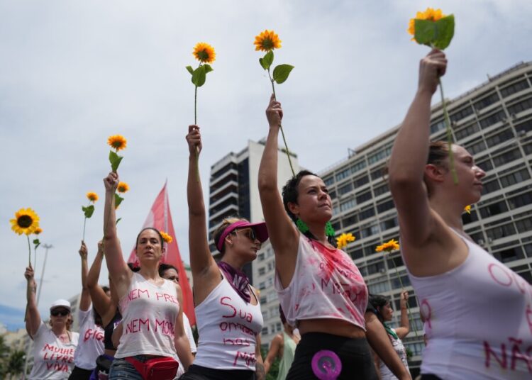 Pictures present girls marking Worldwide Ladies’s Day